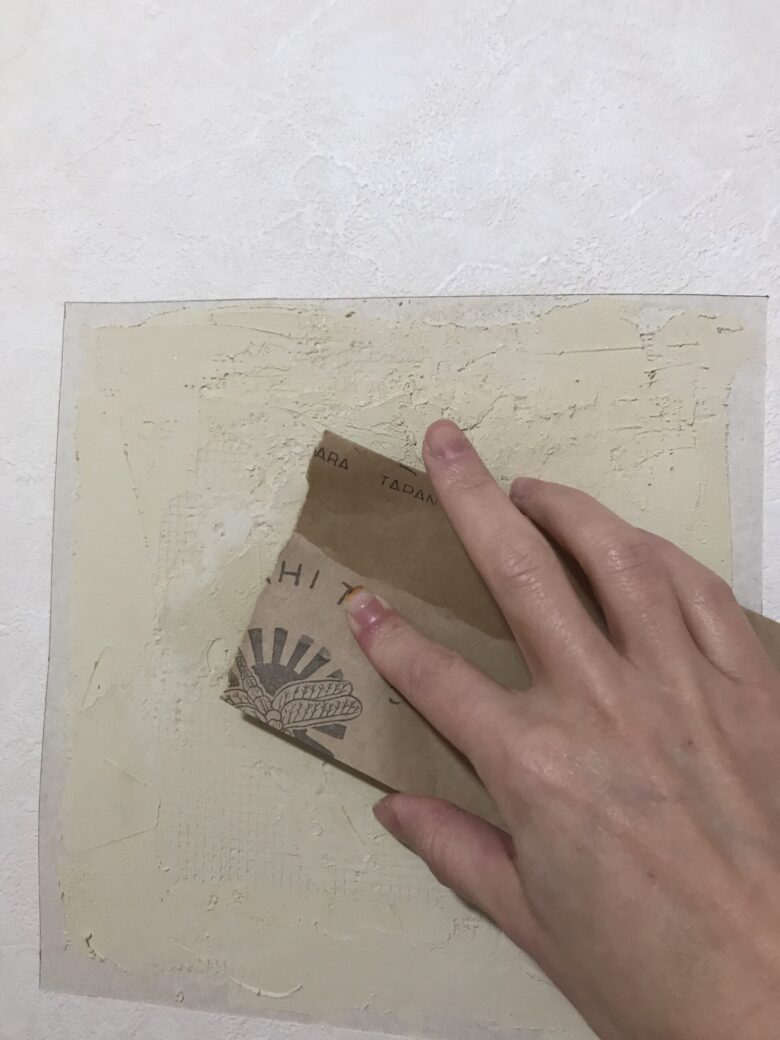 壁のパテに紙やすりをかける